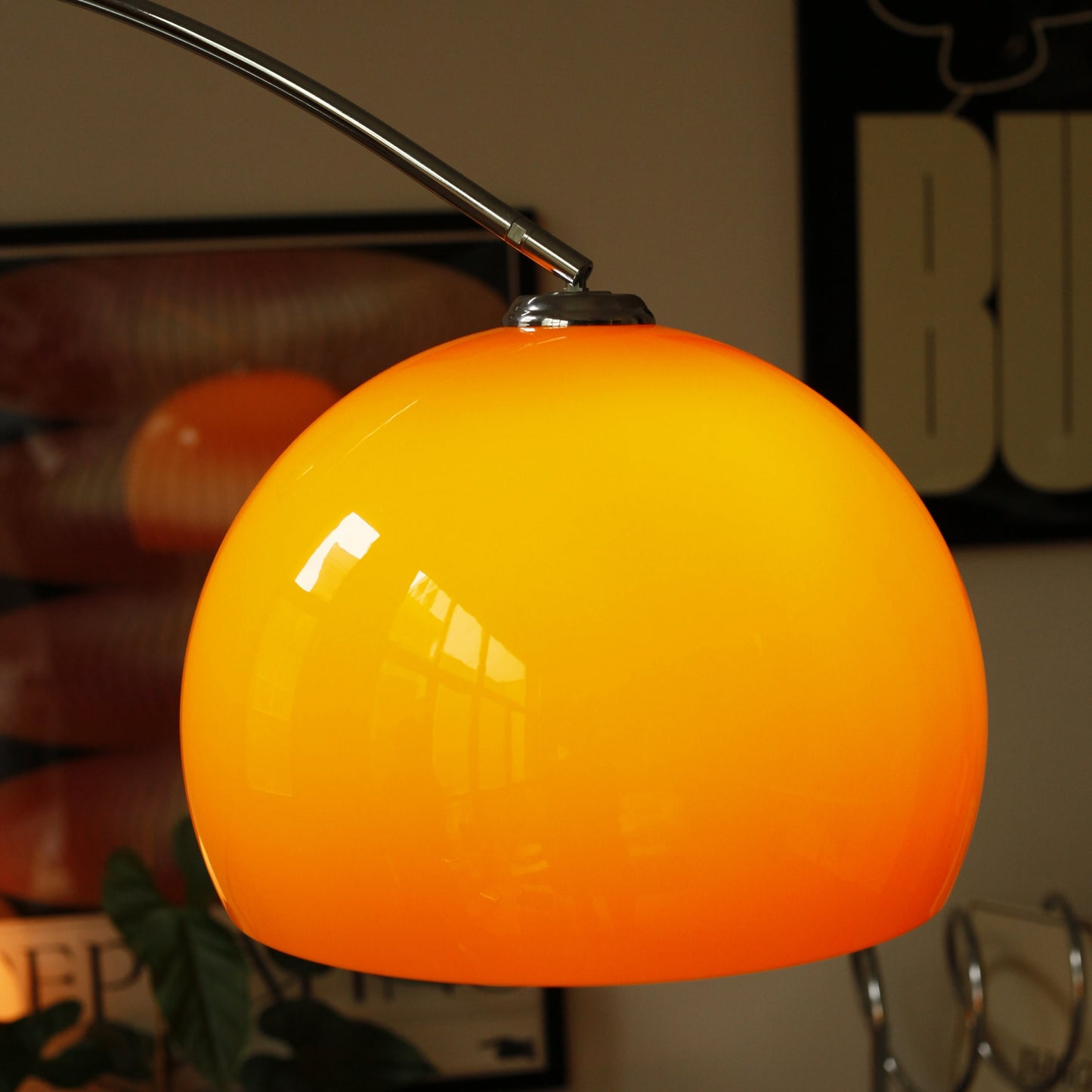 Close-up of orange acrylic shade on Orange Arch Lamp with soft ambient glow
