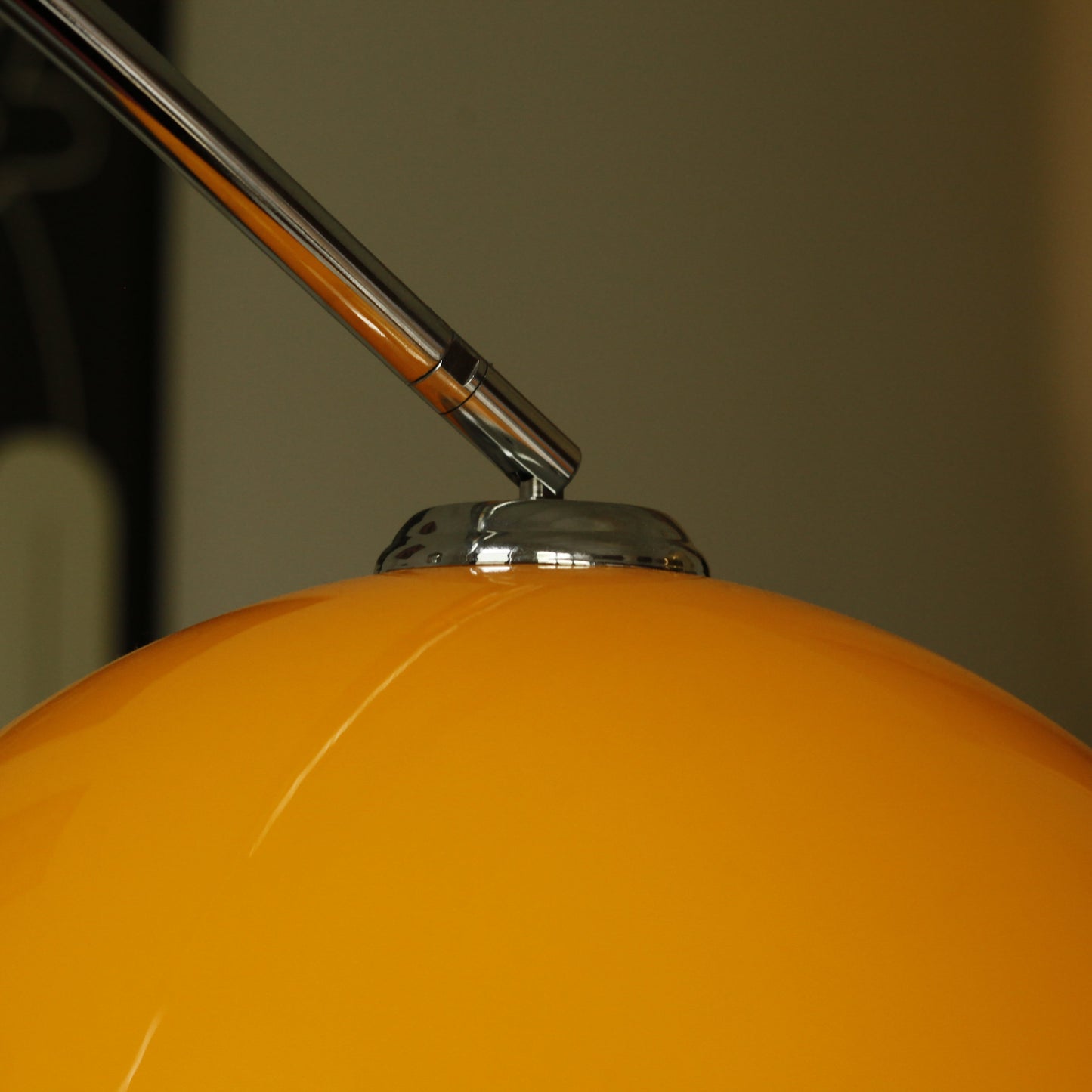 Close-up of orange acrylic shade on Orange Arch Lamp with soft ambient glow