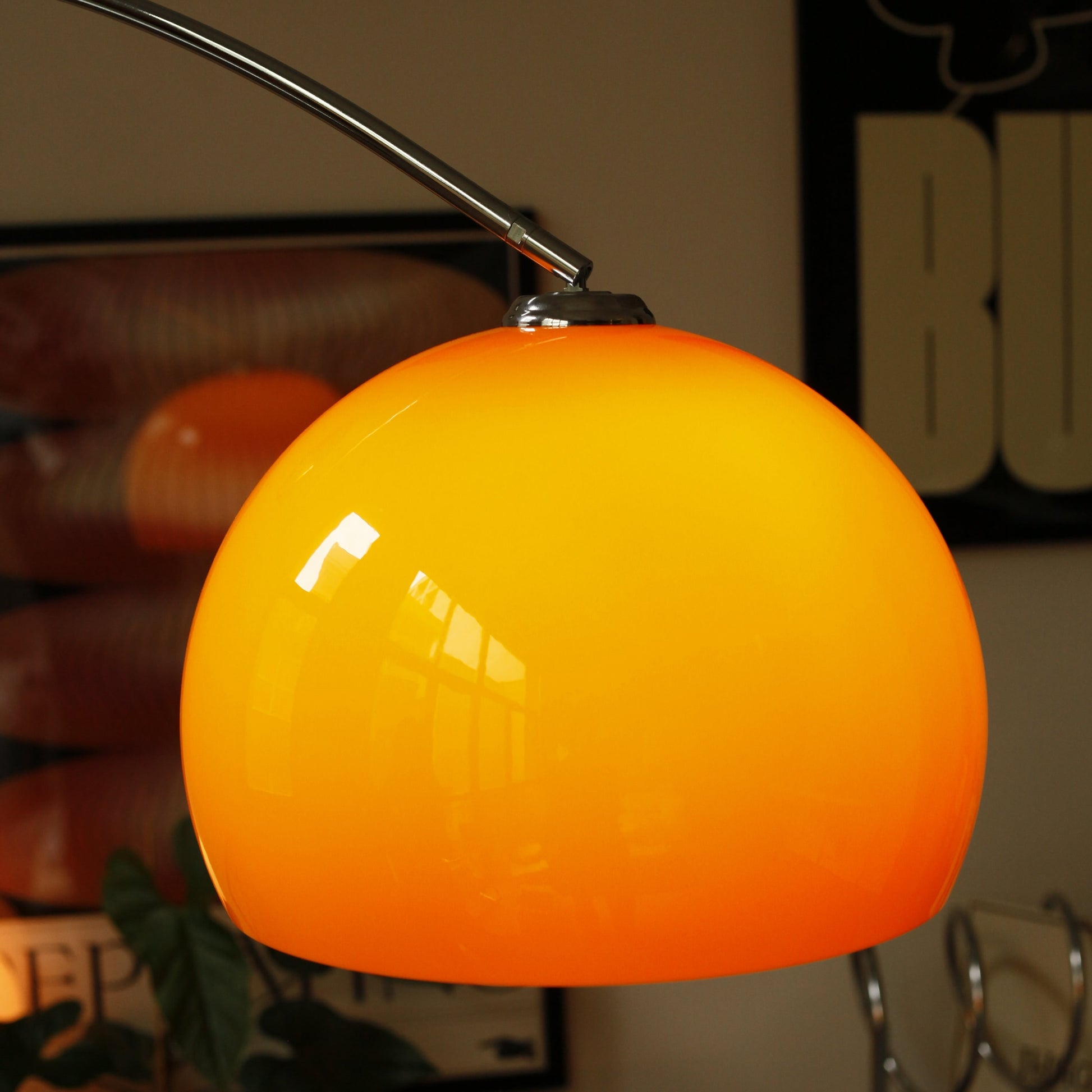 Close-up of orange acrylic shade on Orange Arch Lamp with soft ambient glow