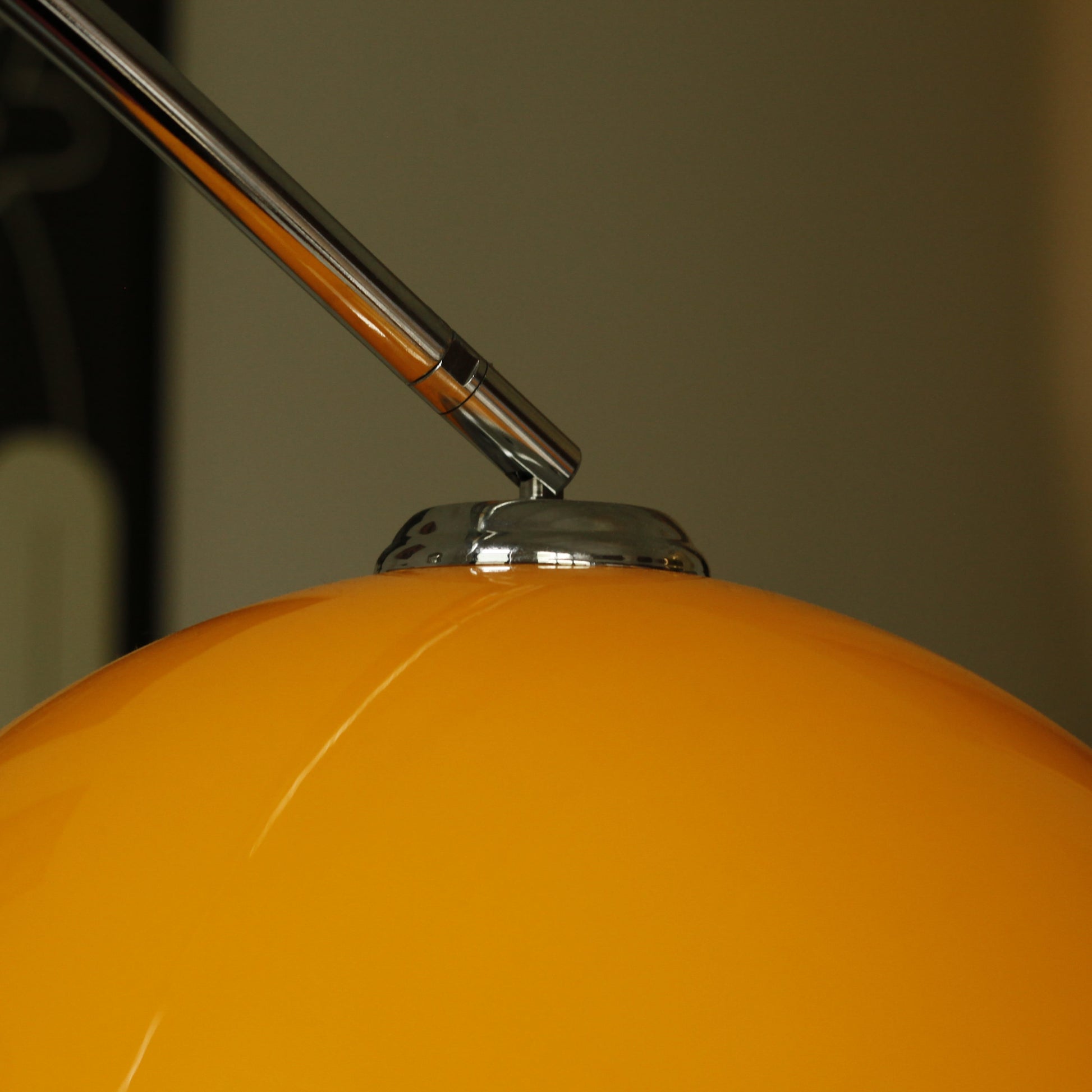 Close-up of orange acrylic shade on Orange Arch Lamp with soft ambient glow